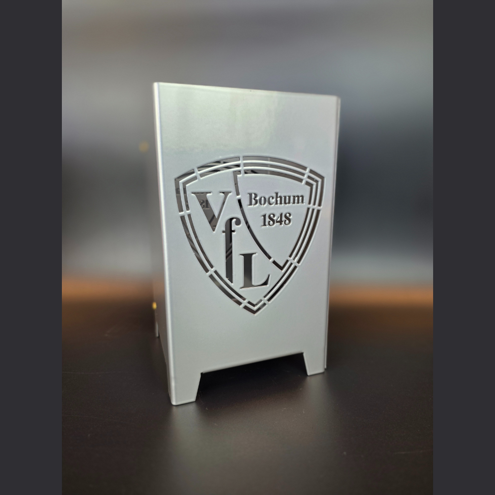 VFL Bochum Logo in ein Metall Windlicht verewigt. In der Abmessung 120 mm mal 120 mm und 200 mm hoch, ist das ein ideales Geschenk für den Fussballfan. Das handgefertigte Windlicht ist in brillant silber pulverbeschichtet.