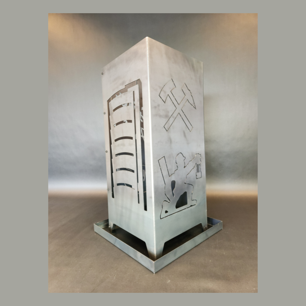 Feuersäule aus Stahl gefertigt in der hauseigenen Produktion. Abmessung 350 x 350 mm und 800 mm hoch. Motiv auf der einen Seite Gasometer, auf der anderen Seite das Motiv: Eisen und Schlägel und darunter ein knieender Bergmann.