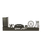 Aus Stahl gefertigt und in schwarz matt pulverbeschichtet. Zum Aufhängen an die Wand. Die Skyline Glück auf beinhaltet den Gasometer, das Stadion von Schalke sowie den Förderturm. Einen Bergmann und eine Lore als Motive.