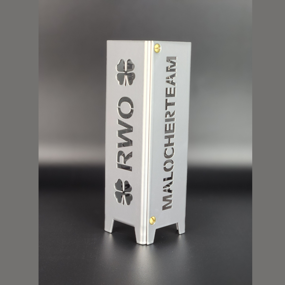 Windlicht mit dem Schriftzug RWO sowie oben und unten jeweils ein Kleeblatt, auf der anderen Seite steht der Schriftzug Malocherteam. Das Windlicht kann mit einem Teelicht beleuchtet werden und ist in Brillant silber pulverbeschichtet. Die Abmessung ist 5