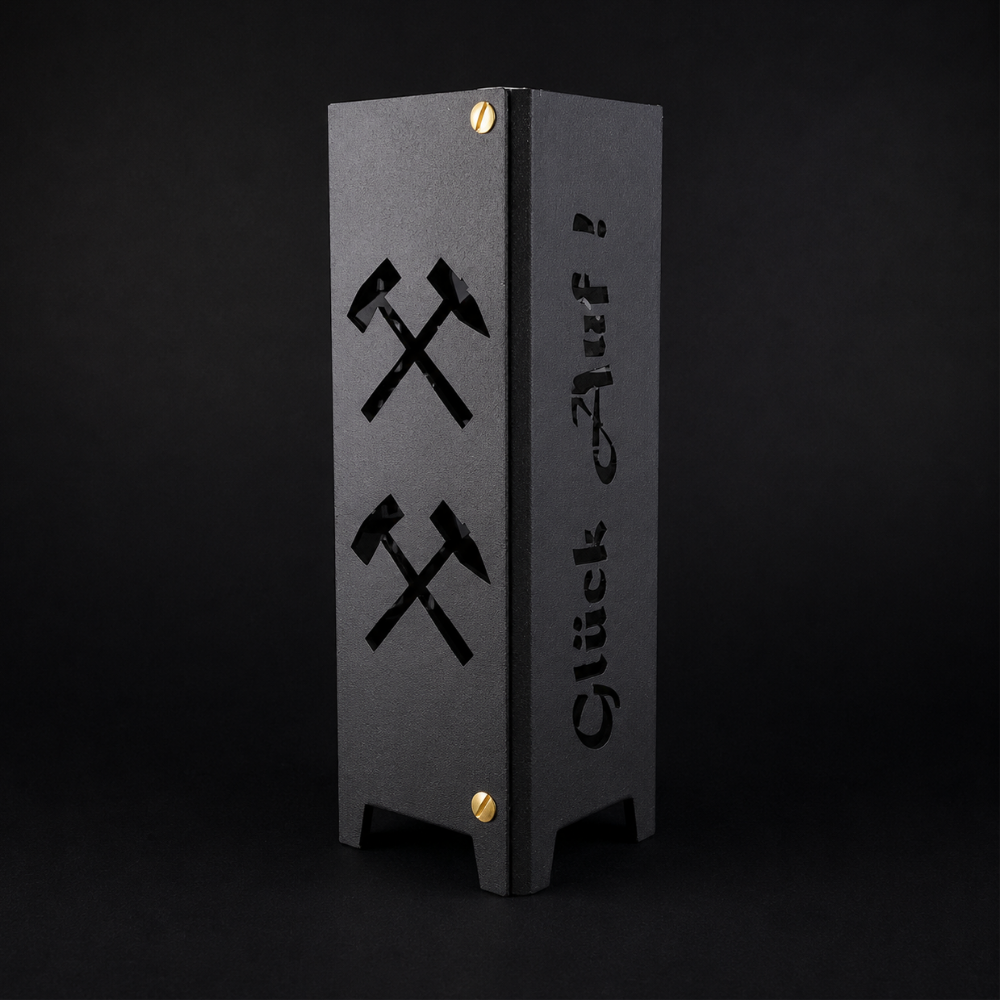 Schwarzes oder brillant silber pulverbeschichtetes Metall-Teelicht im Format 55 × 55 × 175 mm. Die vier Seiten zeigen die gelaserten Motive „Bottrop“, „Glück auf“, einen Förderturm sowie das Symbol Eisen und Schlägel. Das Windlicht erzeugt mit einem Teelicht stimmungsvolle Lichteffekte und eignet sich als Dekoration für den Innenbereich.