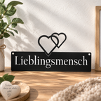 Schwarzes Wandschild aus Metall mit Schriftzug „Lieblingsmensch“ und Herzen