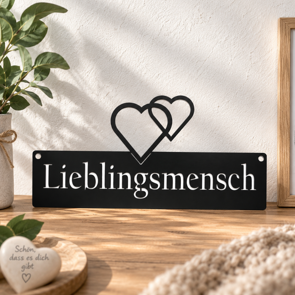 Schwarzes Wandschild aus Metall mit Schriftzug „Lieblingsmensch“ und Herzen
